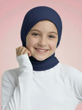 Young girl wearing a navy hijab against a pink background