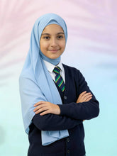 Child wearing a light blue hijab, dark sweater, and striped tie against a pastel background