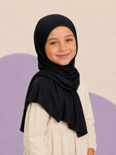 Girl wearing the black jersey hijab for girls, three quarter front view