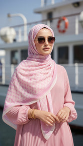 Woman wearing a pink hijab and sunglasses on a boat