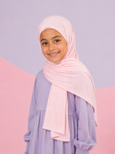 Girl wearing the pale pink jersey hijab for girls, three quarter front view