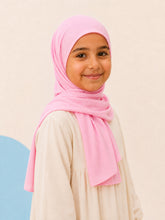 Girl wearing the pink jersey hijab for girls, three quarter front view