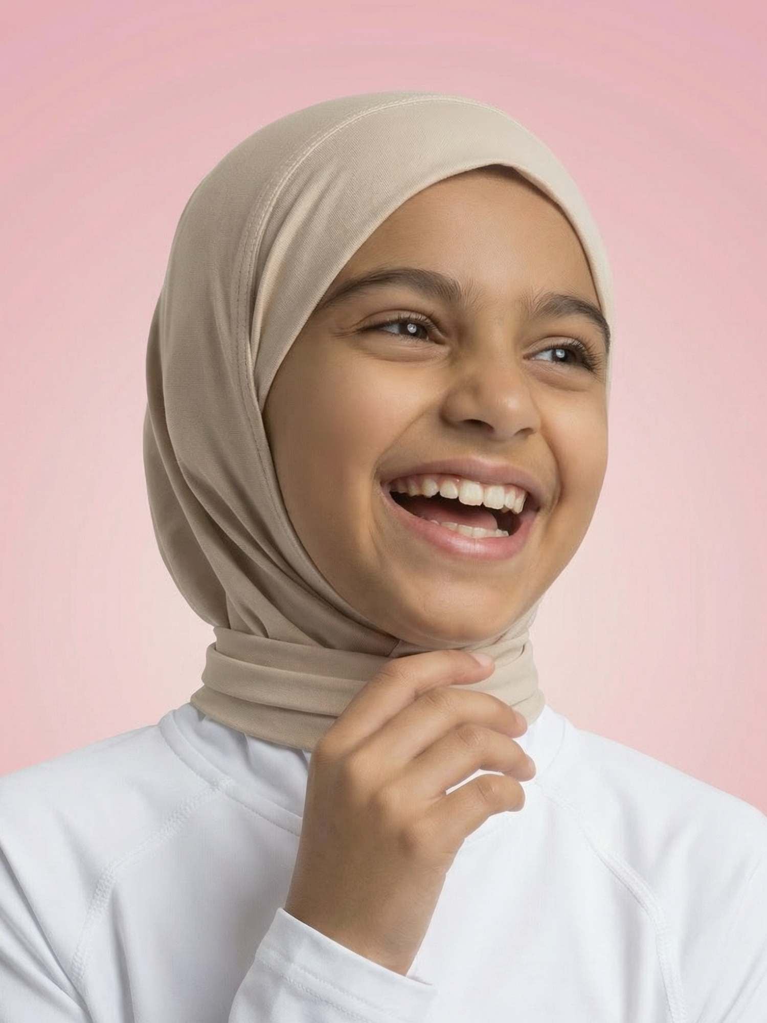 Young girl wearing a beige hijab against a pink background