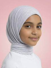 Young girl wearing a light gray hijab against a pink background