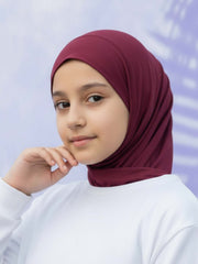 Person wearing a maroon hijab against a light purple background