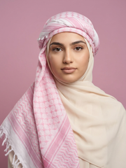 Woman wearing a pink and white patterned headscarf on a pink background