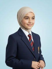 Young girl in a school uniform with a beige hijab on a light blue background