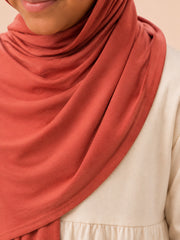 Close up of the rust jersey hijab fabric draped across the shoulder