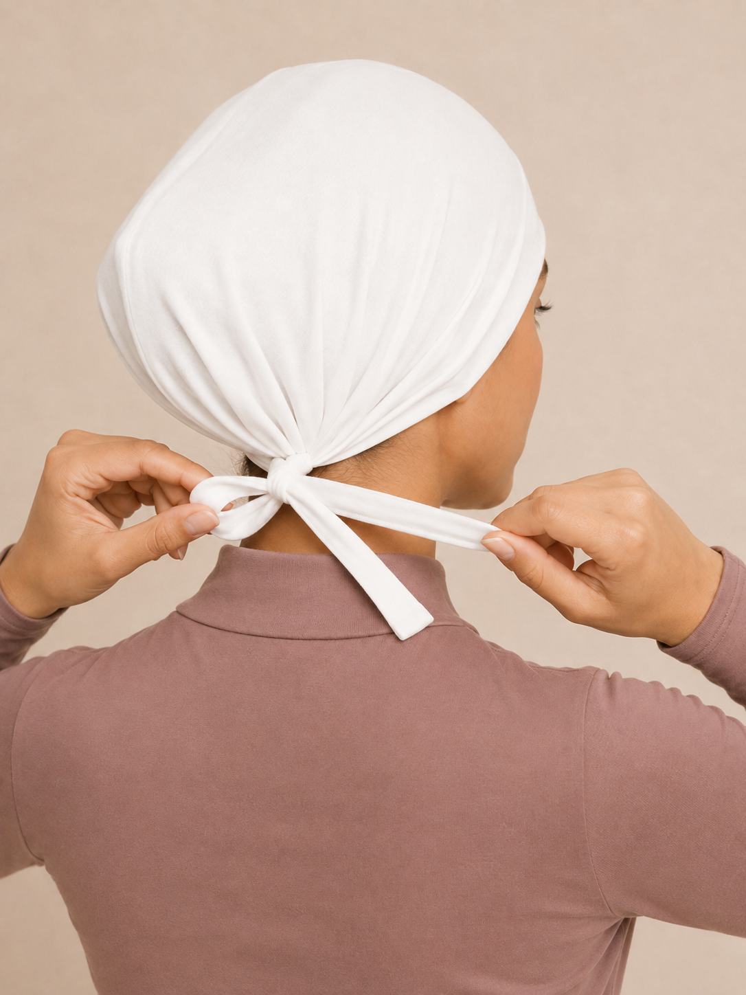 White jersey tie-back undercap, back view showing the adjustable fabric ties tied at the nape